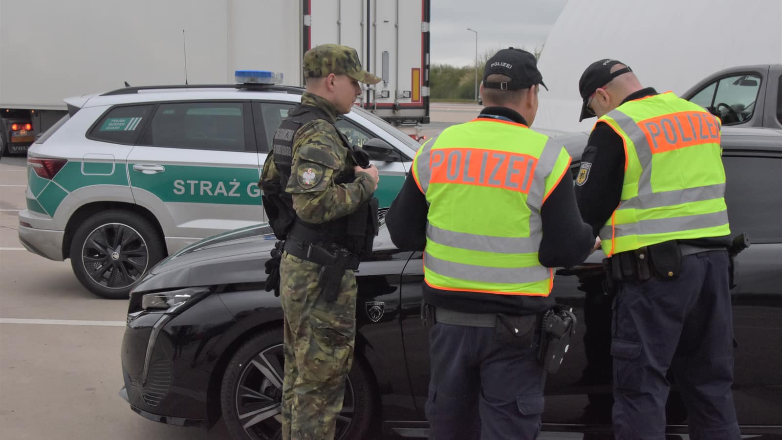 German Federal Police officers and a Polish Border Guard officer checking a car at the German-Polish border