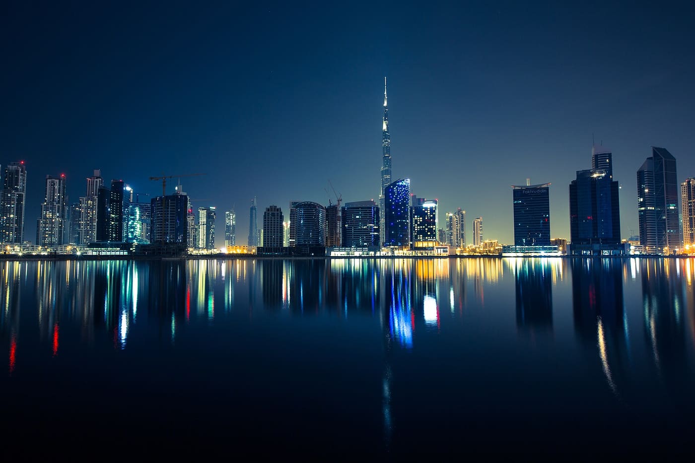 Dubai skyline with the Burj Khalifa reflected in the water at night